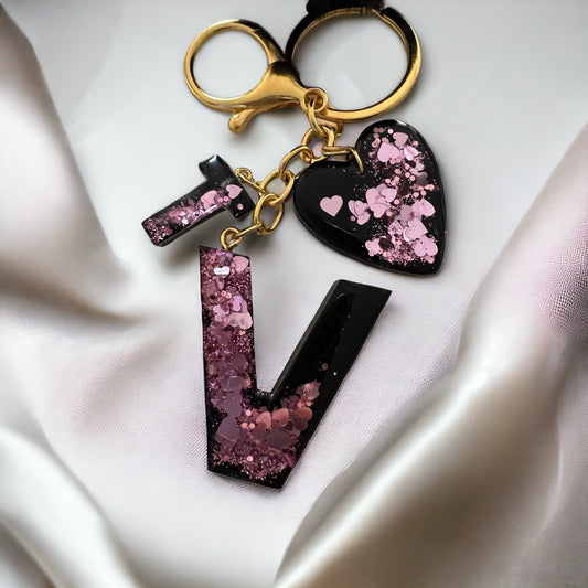 Llavero negro con corazones rosa.