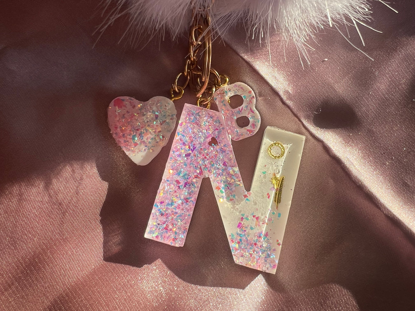 Llavero blanco con purpurina rosa.