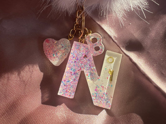 Llavero blanco con purpurina rosa.